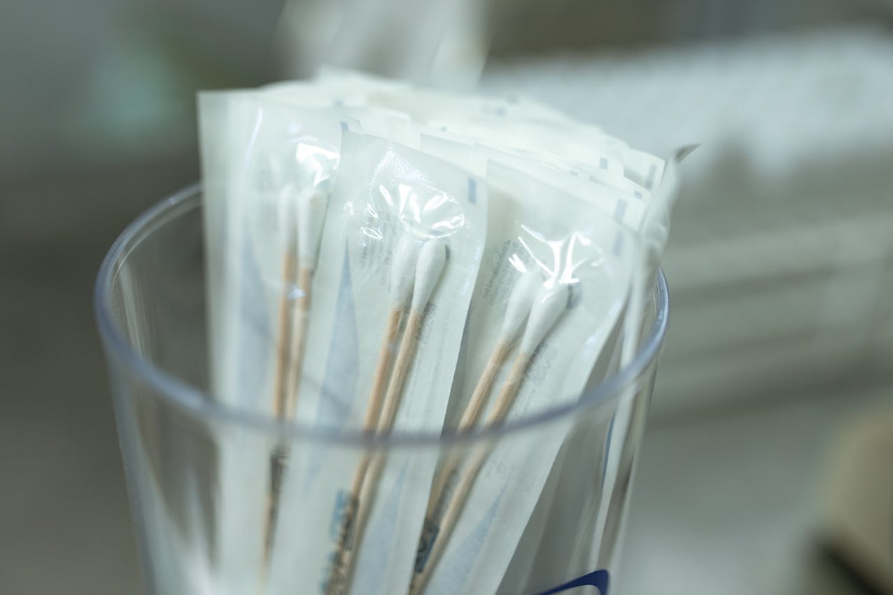 Close-up of individually packaged sterile cotton swabs in a clear holder, ideal for medical use.