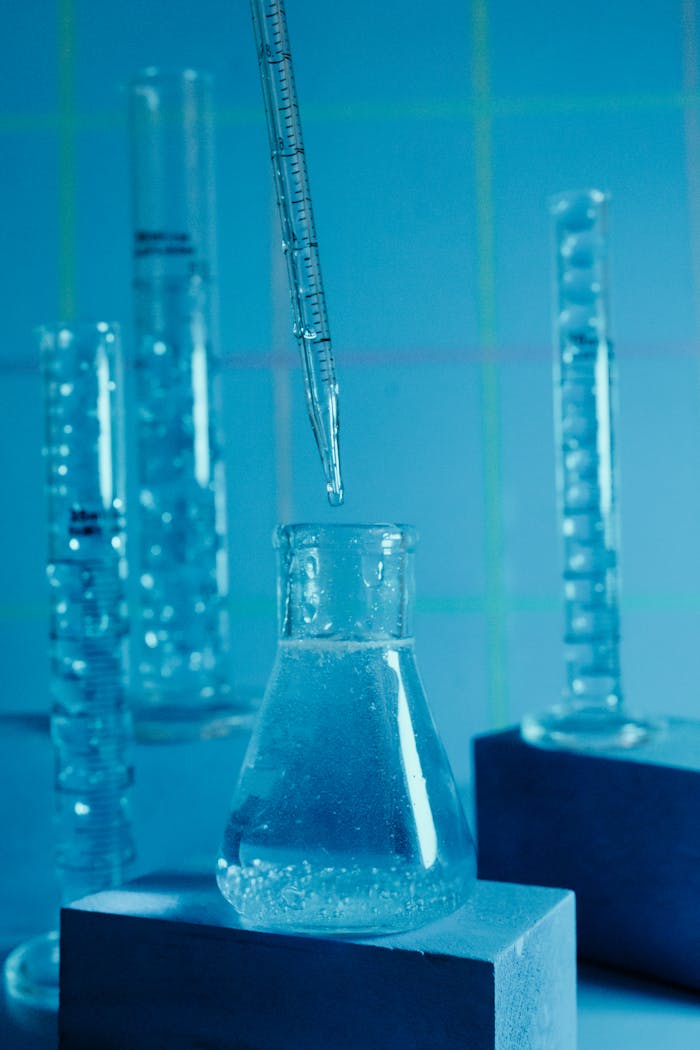 Close-up of laboratory beakers with a pipette, highlighting scientific research.